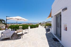 a patio with a table and chairs and an umbrella at Dora's traditional houses in Apollonia