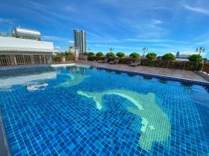 een groot blauw zwembad bovenop een gebouw bij Vareena palace hotel in Noord Pattaya
