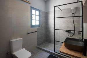 a bathroom with a shower and a toilet and a sink at KYMA Seafront Exceptional 2BD house in Naousa in Naousa +73 photos