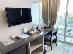 een bureau in een kamer met een televisie aan de muur bij Vareena palace hotel in Noord Pattaya