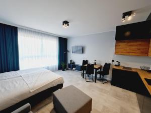 a bedroom with a bed and a table and chairs at Apartament Wałowa in Gdańsk