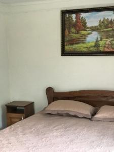 um quarto com uma cama com uma fotografia na parede em Підскельний em Yaremche