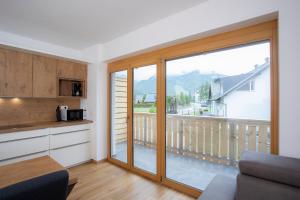 克拉尼斯卡戈拉Apartment Bistra Kranjska Gora的厨房设有大型滑动玻璃门和阳台