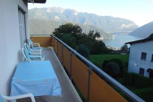 balcone con tavolo, sedie e vista di Wohnung mit See Sicht in Carona a Carona