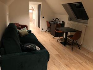 ein Wohnzimmer mit einem grünen Sofa und einem Tisch in der Unterkunft Hof Van Volmersele - Luxury B&B in Kampenhout