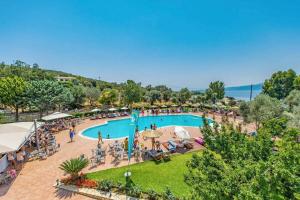 an outdoor swimming pool with people sitting around it at Evia Riviera Resort by Anayia All Inclusive Resorts in Amarynthos