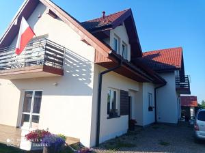 Casa con balcón y bandera en Oaza Świętokrzyska, en Wola Kopcowa
