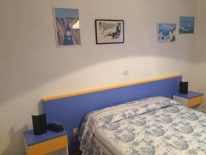ein Schlafzimmer mit einem Bett mit zwei Nachttischen und zwei Bildern in der Unterkunft Hotel Halifax in Lido di Jesolo