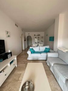 a living room with two white couches and a tv at Appartement Paraiso Riviera del Sol-Mijas in Málaga