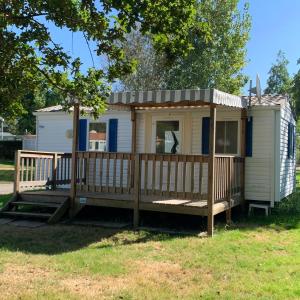 a tiny house with a porch and a deck at Camping le Village de Florine in Coëx