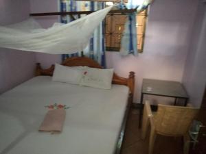 a small bedroom with a bed with a window at Kicec bar and guest house airport in Dar es Salaam