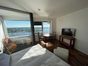 a bedroom with a bed and a living room with a view at Inselblick in Schleswig