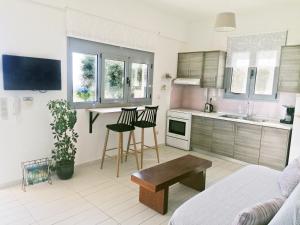 a living room with a couch and a kitchen with a table at Kalliroi by KRISSES in Míloi