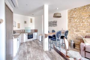 a kitchen and living room with a stone wall at L'Escapade à Lascaux in Montignac