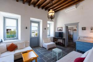 a living room with a couch and a tv at Dora's traditional houses in Apollonia