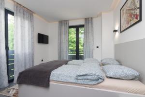 a bedroom with a bed with pillows and a television at Deluxe Feliciano Apartments in Visoko +101 photos