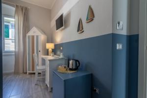 ラ・スペツィアにあるAquamarinaの青い壁の客室で、テーブル、デスクが備わります。