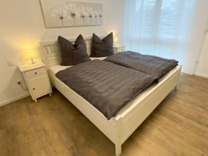 a bedroom with a large white bed with two pillows at Ferienwohnung Bauer in Eppingen