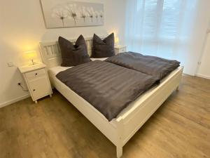 een slaapkamer met een groot wit bed met 2 kussens bij Ferienwohnung Bauer in Eppingen
