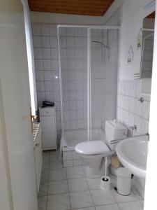 ein Badezimmer mit einer Badewanne, einem WC und einem Waschbecken in der Unterkunft Apartment Kletterrose am Krakower See in Kuchelmiß