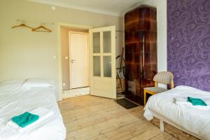 1 dormitorio con 2 camas y pared púrpura en Artists Apartment near Telliskivi Creative Centre, en Tallin