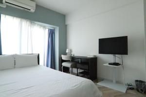 una camera da letto con un letto, una scrivania e una televisione di PG Kuromon ad Osaka