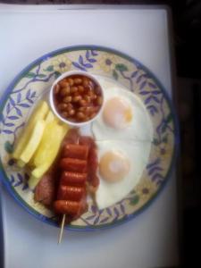 a plate of breakfast food with eggs beans and fruit at Birdcage B&B in Amanzimtoti