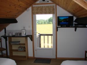 a room with a door and a balcony with a television at La Blanche Roche in Sourdeval