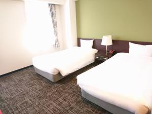Habitación de hotel con 2 camas y ventana en Hotel Bougain Villea Sapporo en Sapporo