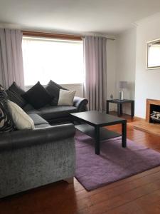 a living room with a couch and a coffee table at ACE Largs Ground Floor Apartment with Garden in Largs