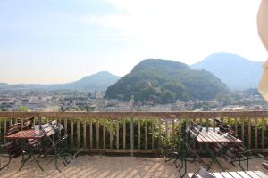 a balcony with two chairs and a view of a city at Stadtalm Naturfreundehaus in Salzburg
