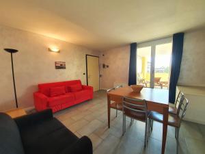 uma sala de estar com um sofá vermelho e uma mesa em Residence Hotel Hungaria em Grado