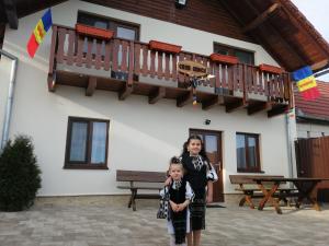 deux enfants debout devant un bâtiment dans l'établissement Casa Iancu, à Jina