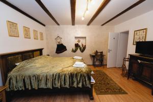 a bedroom with a bed and a television in it at Pensiunea Grosspold in Miercurea Sibiului