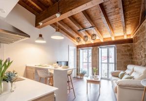 a kitchen and living room with wooden ceilings at Apartamentos Turísticos de La Vega in Haro