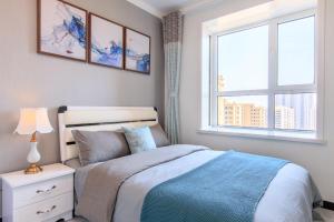 a bedroom with a bed and a window at Baoding Lianchi·Baoding East Station· in Baoding