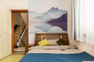 um quarto com uma cama com um mural de montanha na parede em Henan Kaifeng·Millennium City· Locals Apartment 00139400 em Kaifeng