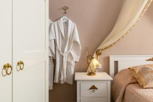 a bedroom with a white robe hanging on a wall at Marika's Deluxe Rooms in Symi