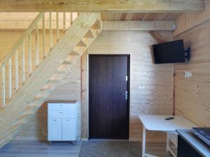 a wooden door in a room with a staircase at Domki u Iwonki -brązowy in Niechorze