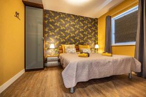 a bedroom with a bed and a yellow wall at De Heerlijkheid Hensbroek in Hensbroek