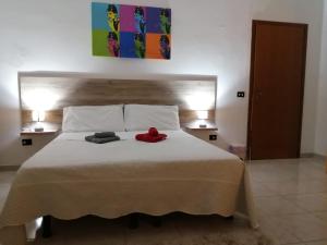 un lit avec deux serviettes et un animal en peluche rouge dessus dans l'établissement Sweet Home Montecristo Civico 1, à Vibo Valentia