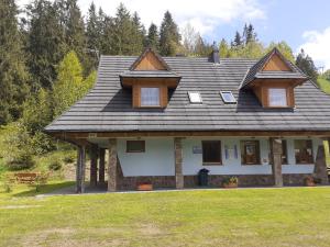 a house with a gambrel roof on top of it at Domek HAWRAŃ in Jurgów