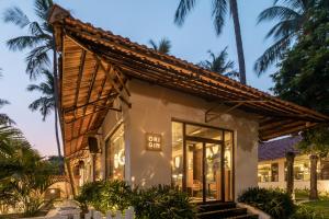 a store front of a house with palm trees at Green Meadows Resort in Chennai
