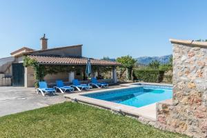 a villa with a swimming pool and blue chairs at Villa Catalina Petit in Pollença