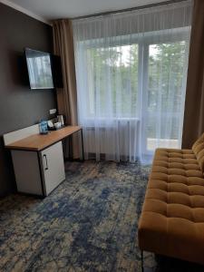 um quarto de hotel com uma secretária e uma grande janela em Bel-Ami em Zakopane