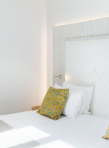 a white bedroom with a bed with white pillows at Le Parisis - Paris Tour Eiffel in Paris