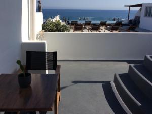 a patio with chairs and a table and the ocean at Almyra Oia Suites in Oia