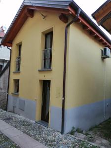a yellow house with a door and a balcony at La Casetta di Baveno in Baveno