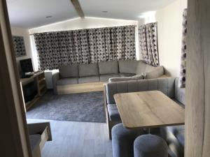 a living room with a couch and a table at Exclusive 3 Bedroom Caravan, Sleeps 8 People at Parkdean Newquay Holiday Park, Cornwall, UK in Newquay Bay Resort