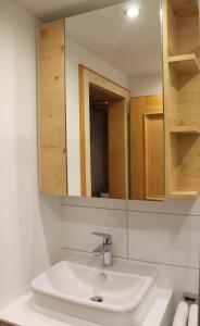 een witte wastafel in een badkamer met een spiegel bij Haus Schönblick in Brand +31 foto's